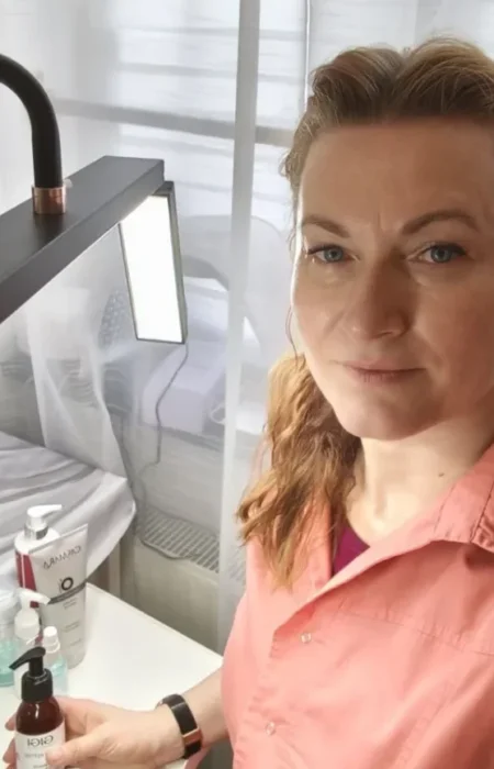 Kosmetikerin Oksana mit einer Flasche Kosmetik in der Hand